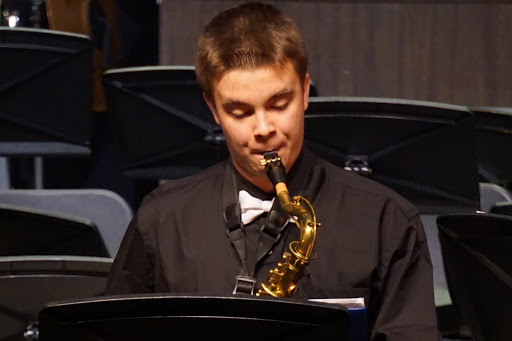 Photo of Trevor Burns playing tenor saxophone at concert.